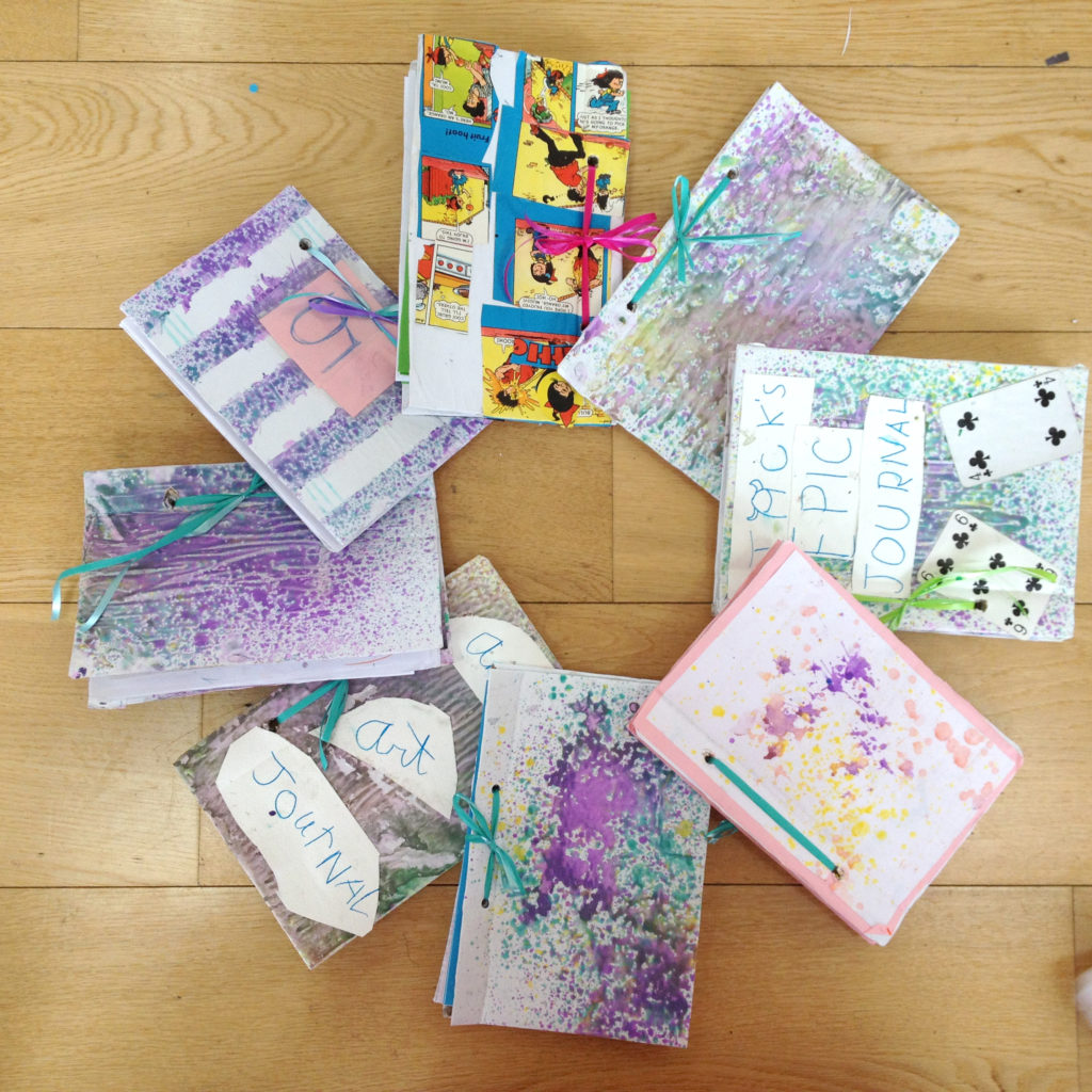 spray painting notebooks with kids at our summer camps