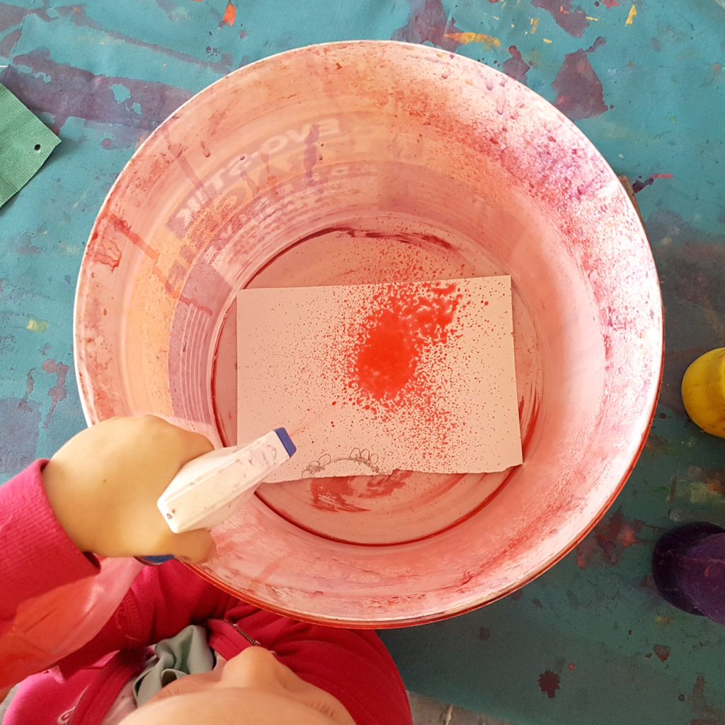 Spray painting with kids using an old plastic bucket